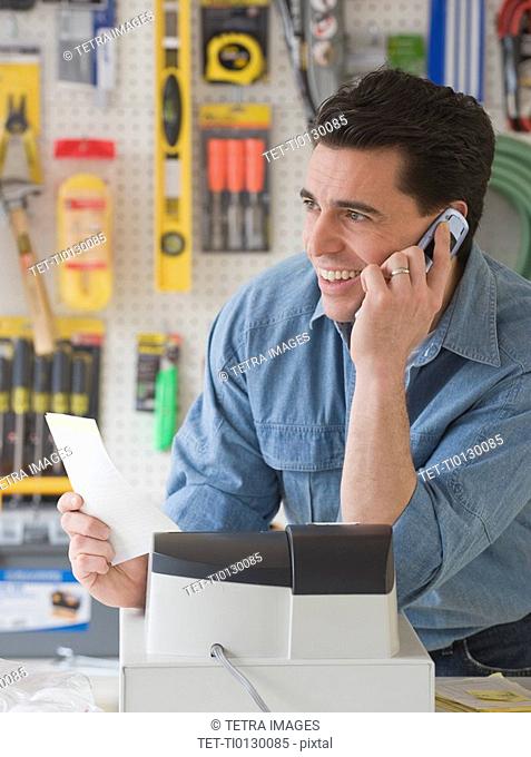 Sales clerk talking on telephone in hardware store