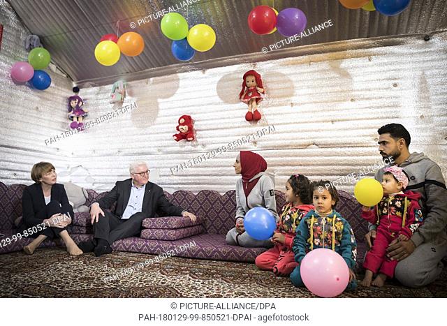 HANDOUT - German President Frank-Walter Steinmeier and his wife Elke Buedenbender (l) visit a family of refugees at the displaced persons camp 'Al Azraq' in...