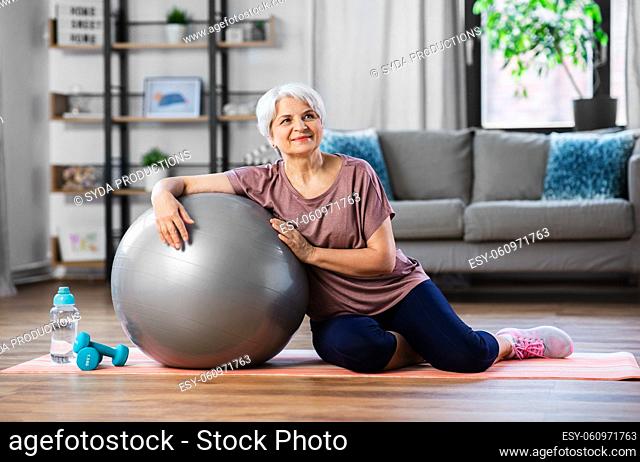smiling senior woman with exercise ball at home
