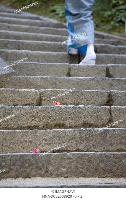 Woman's feet in kimono with Zouri (Japanese sandals) on stone stairs