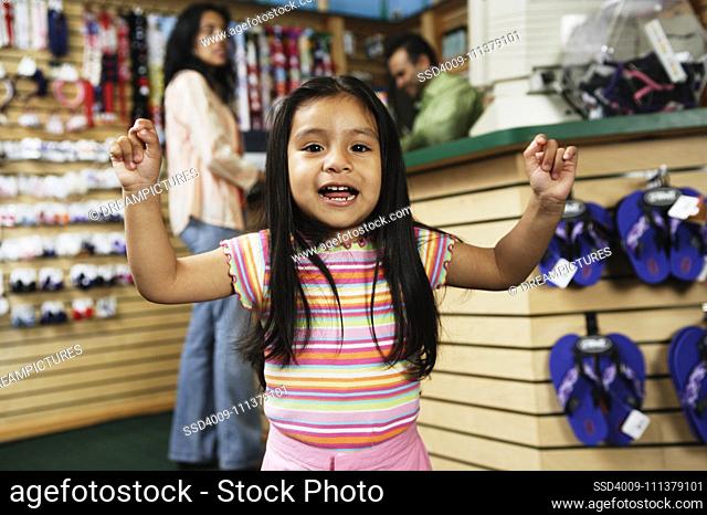 Young Hispanic girl cheering at shoe store