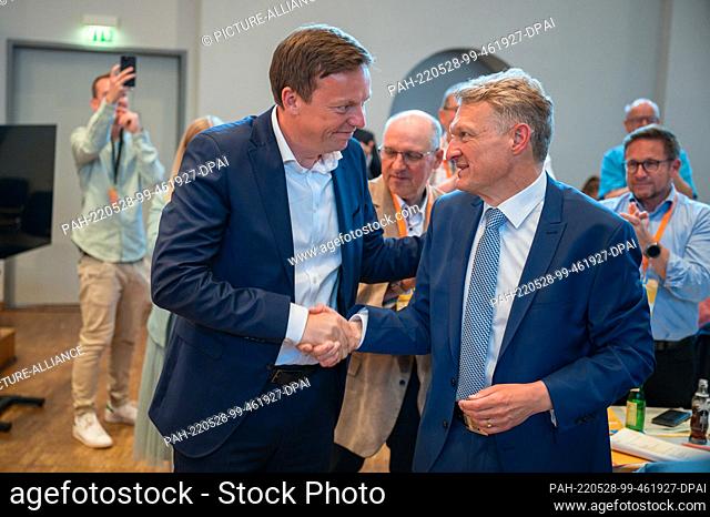 28 May 2022, Saarland, Eppelborn: Tobias Hans (CDU, l) congratulates Stephan Toscani (CDU) at the 71st state party conference of the CDU Saar after Toscani's...