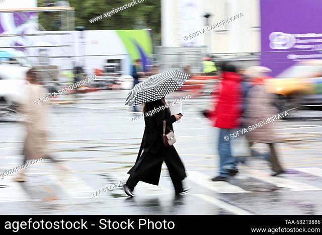 RUSSIA, MOSCOW - OCTOBER 9, 2023: A woman takes shelter under an umbrella during the rain. Sofya Sandurskaya/TASS