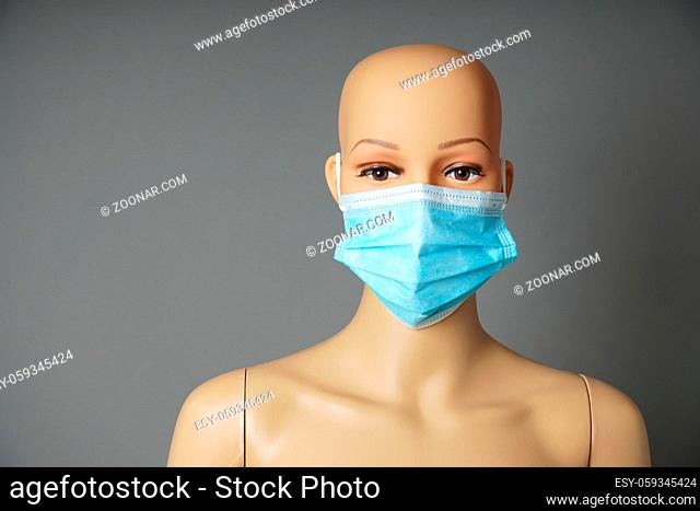 a shop window mannequin or display dummy head wearing medical face mask