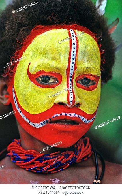 A Huli boy with traditional yellow and red painted face Tari, Southern Highlands, Papua New Guinea