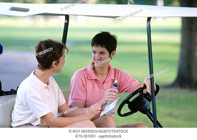two women in a golf cart