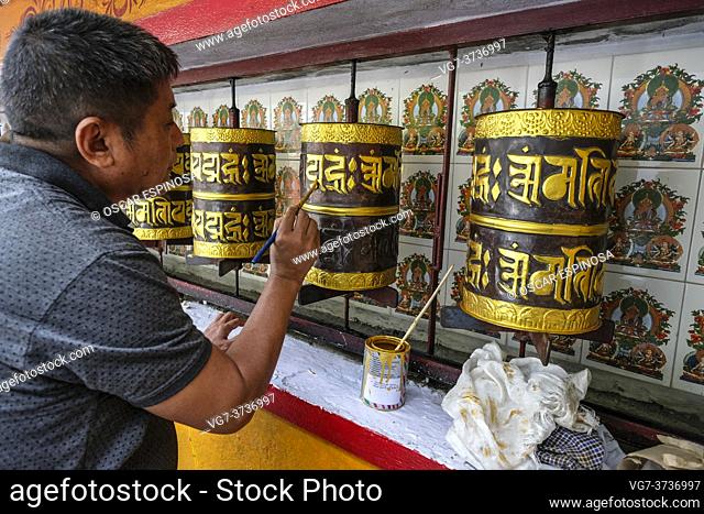 Gangtok, India - October 2020: A man painting the prayer wheels of the stupa in the stupa in the Sera Jey Drophenling Monastery in Gangtok on October 23