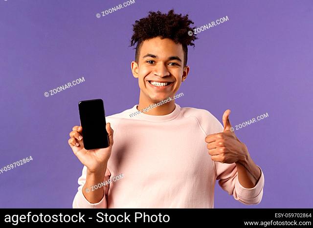 Close-up portrait of cheerful, satisfied young male customer recommend buying subscribtion to game or app, learning leanguage via application mobile phone