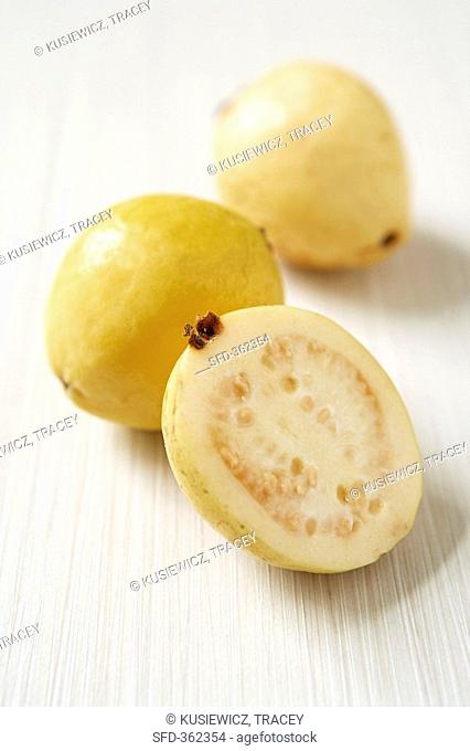 Two whole yellow guavas and half a guava