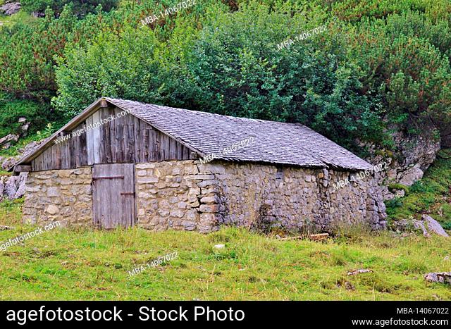 hike to the zireiner see 4 hectare mountain lake at 1799 m in the brandenberg alps, tyrol, münster municipality, old stone-walled alpine hut with shingle roof