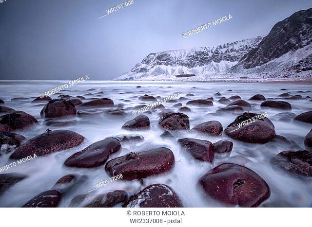 Rocks on the beach modeled by the wind surround the icy sea, Unstad, Lofoten Islands, Arctic, Norway, Scandinavia, Europe