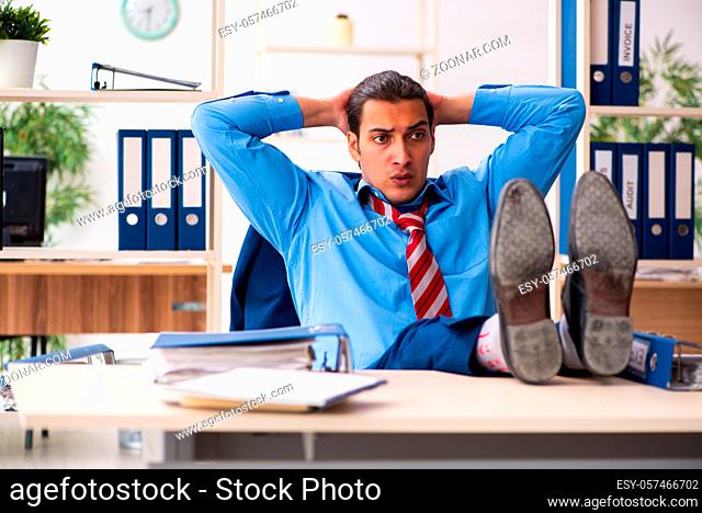 Young businessman doing sport exercises at workplace