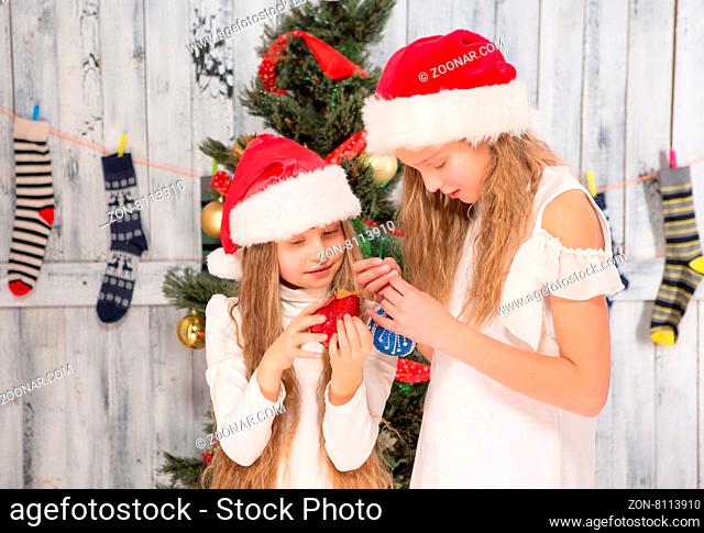 New Year and Christmas concepts. Teenage girls discussing several moments concerning decorating New Year tree at home