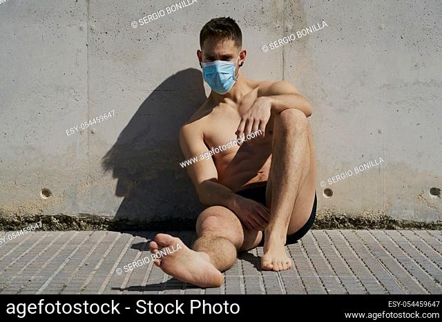 Portrait of a gorgeous guy wearing a mask to avoid infection. Coronavirus concept