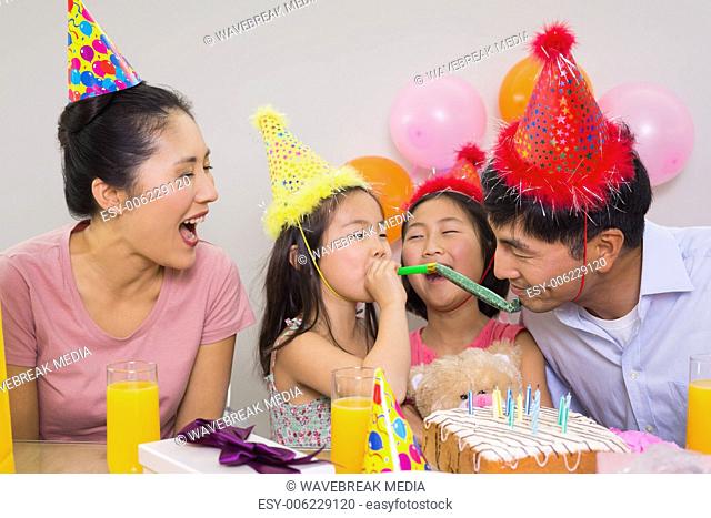 Cheerful family with cake and gifts at a birthday party