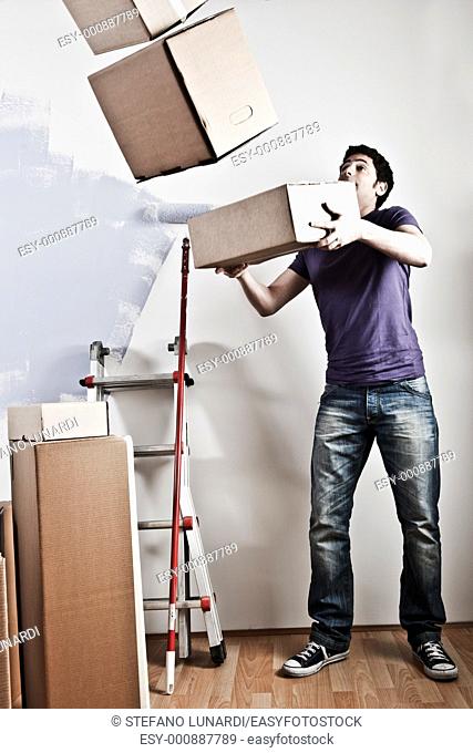Man Carrying Stacked Boxes on moving day, desaturated image