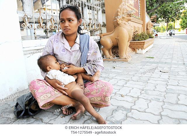 Cambodian Woman breastfeeding her child on a street in Phnom Penh