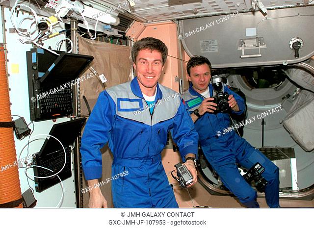 Expedition 1 cosmonauts Sergei K. Krikalev, flight engineer, and Yuri P. Gidzenko, Soyuz commander, are pictured with camera gear in the forward portion of the...