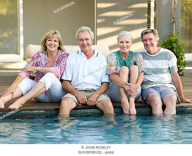 Mature friends by swimming pool