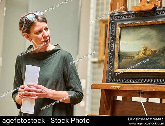 31 March 2022, Berlin: Katja Kleinert, curator of the Gemäldegalerie, stands next to the painting ""Landscape with Arched Bridge"" in the Gemäldegalerie...