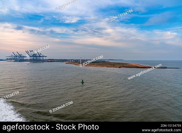 Felixstowe, Suffolk, England, UK - April 23, 2019: Approaching the harbour from the seaside, with port cranes in the background
