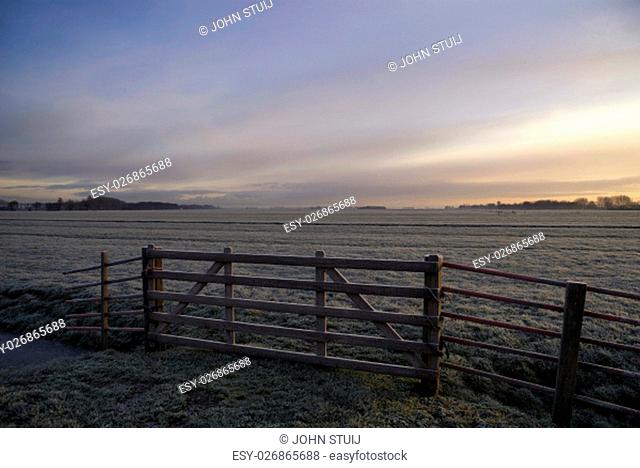 Gate in front of a frosted pasture near Wijngaarden in the Dutch region Alblasserwaard.