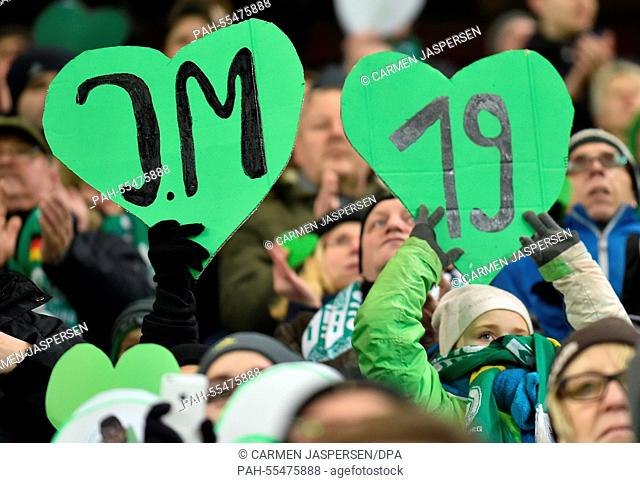 Wolfsburg's fans hold high signs with the number and the initials of Junior Malanda who suffered a fatal accident, during the German Bundesliga soccer match VfL...