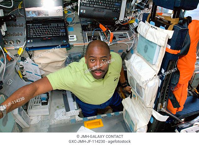 Astronaut Leland Melvin, STS-129 mission specialist, is pictured in the hatch which connects the flight deck and middeck of Space Shuttle Atlantis during flight...