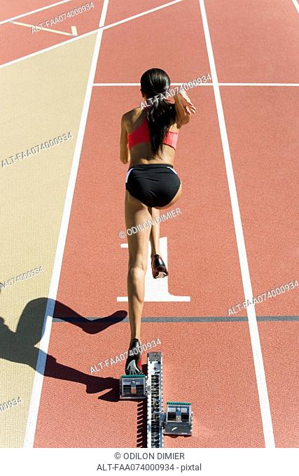 Female runner at starting line, rear view