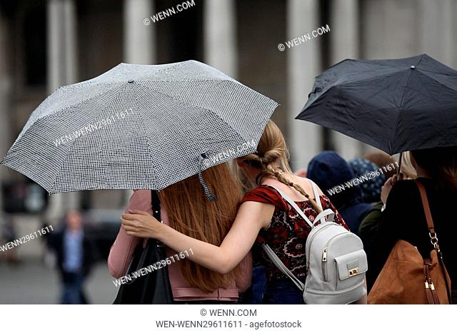 People in heavy rain and windy conditions in Trafalgar Square, London Featuring: Atmosphere Where: London, United Kingdom When: 29 Sep 2016 Credit: WENN