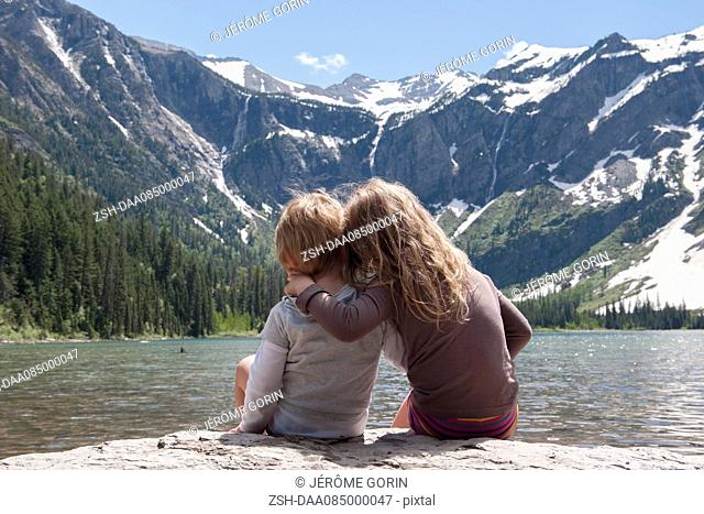 Young siblings enjoying view of mountains in Glacier National Park, Montana, USA
