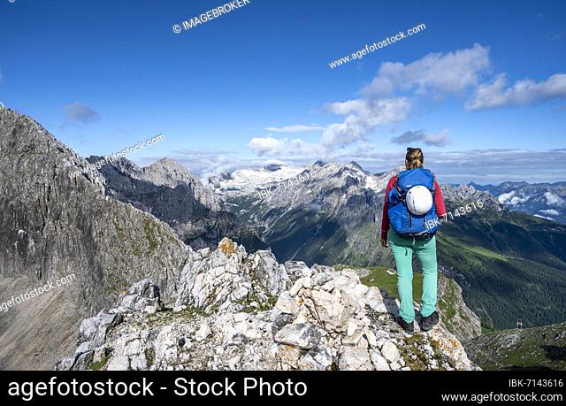 Hiker on a summit, Westliche Törlspitze, mountains in dramatic clouds, middle Zugspitze, Wetterstein Mountains, Garmisch-Partenkirchen, Bavaria, Germany, Europe