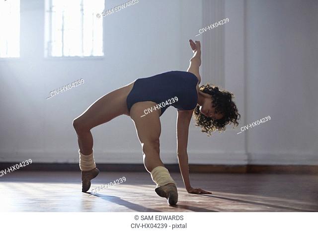 Strong young female dancer practicing in dance studio