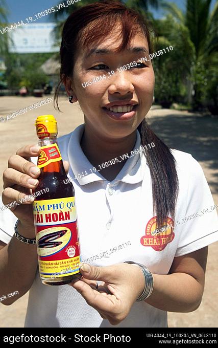 Young woman with bottle of fish sauce at fermentation plant Duong Dong town Phu Quoc island Vietnam
