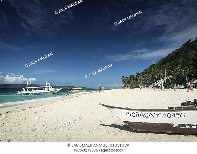 tourist boats on puka beach resort in tropical paradise boracay island Philippines