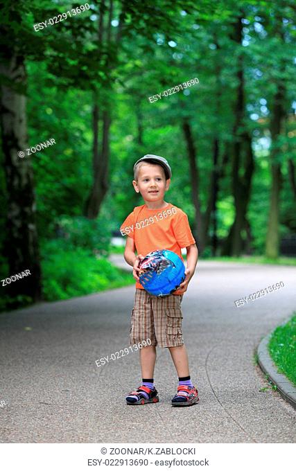Boy playing with ball in park outdoors