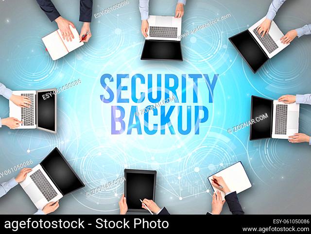 Group of people in front of a laptop with SECURITY BACKUP insciption, web security concept