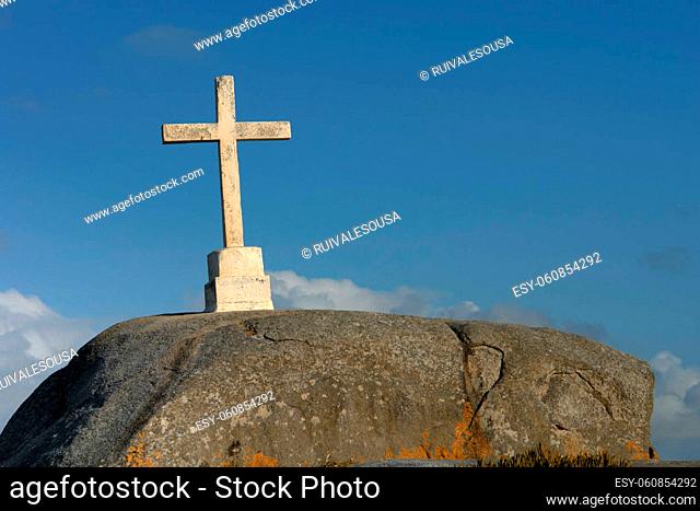 rock with a cross and the clouds at the blue sky