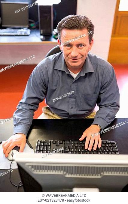 Mature student happily working on computer in class