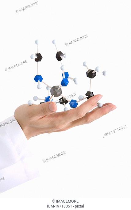 One man holding molecular structure, focus on hand, close up
