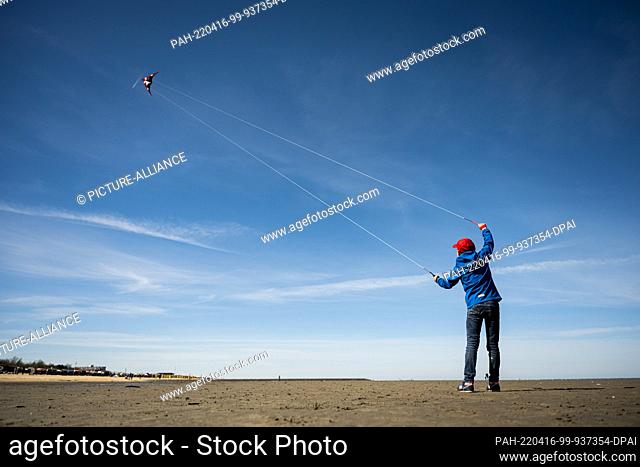 16 April 2022, Lower Saxony, Cuxhaven: A boy flies his kite on the North Sea beach of Cuxhaven in nice weather. Photo: Mohssen Assanimoghaddam/dpa
