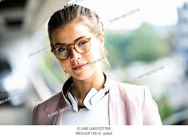 Portrait of a young businesswoman with headphones around her neck