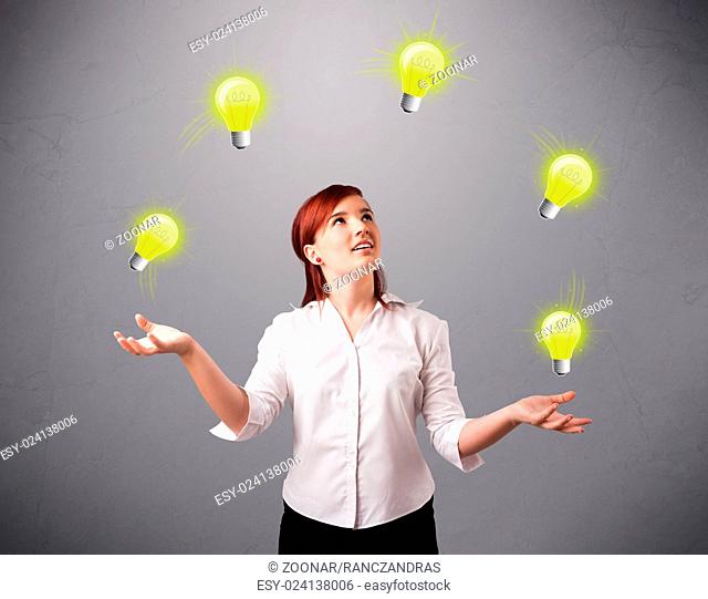 young lady standing and juggling with light bulbs