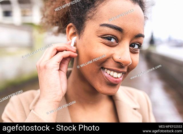 Portrait of smiling young woman with earbuds