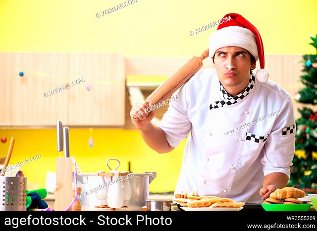 Young chef husband working in kitchen at Christmas eve