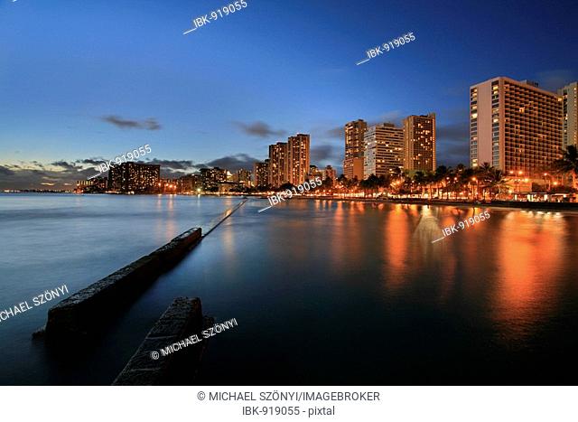 Beach, pier and hotel complexes in Waikiki at dusk, O'ahu Island, Hawaii, USA