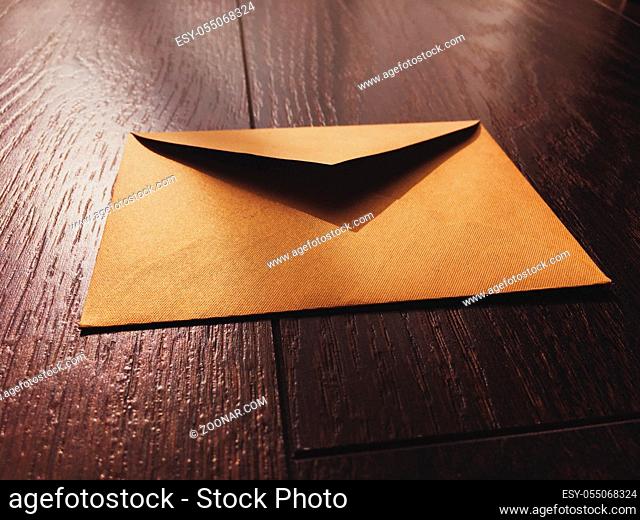Golden vintage envelope on wooden background, newsletter and message concept