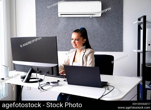Happy Businesswoman Working In Office With Air Conditioning