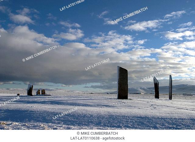 Stone Age archaeological site. Standing stones of Stenness. Stone circle. Tall stones upright in ground. Snow covering. Low grey cloud