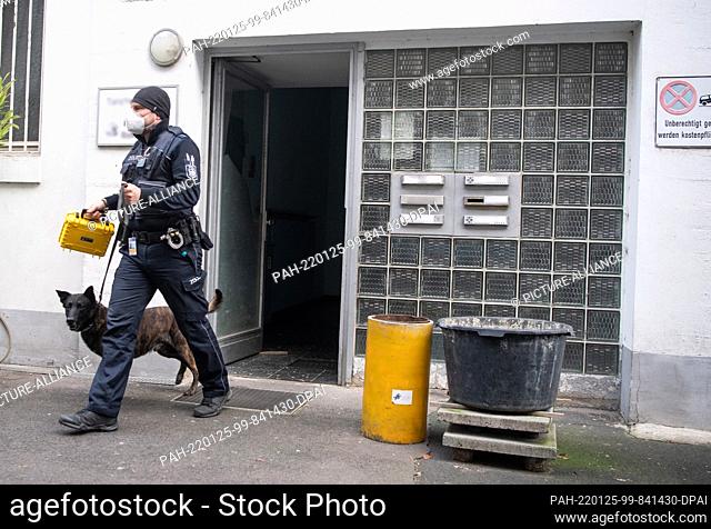 19 January 2022, Hessen, Frankfurt/Main: A customs dog handler leaves an office building in Frankfurt with a drug-sniffing dog during a raid against illegal...